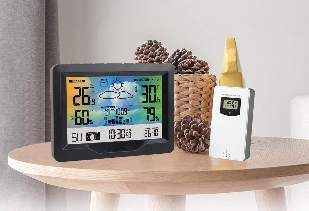 stazione meteo su un tavolino con accanto sensore esterno